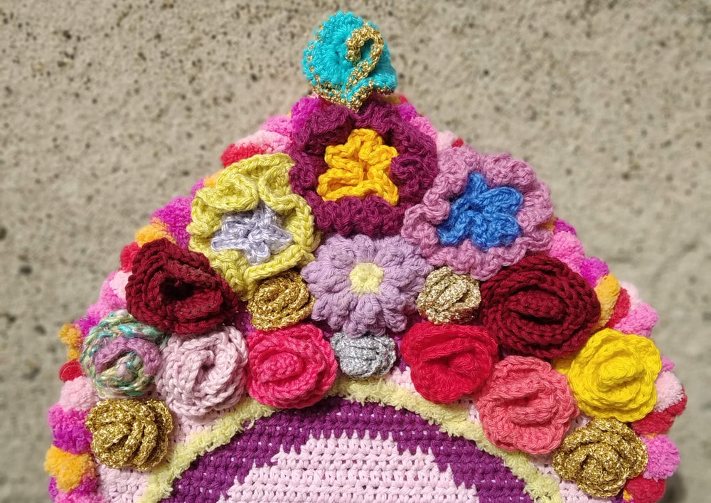 détails d'une pièce textile avec des fleurs de toutes les couleurs réalisées au crochet et assemblées