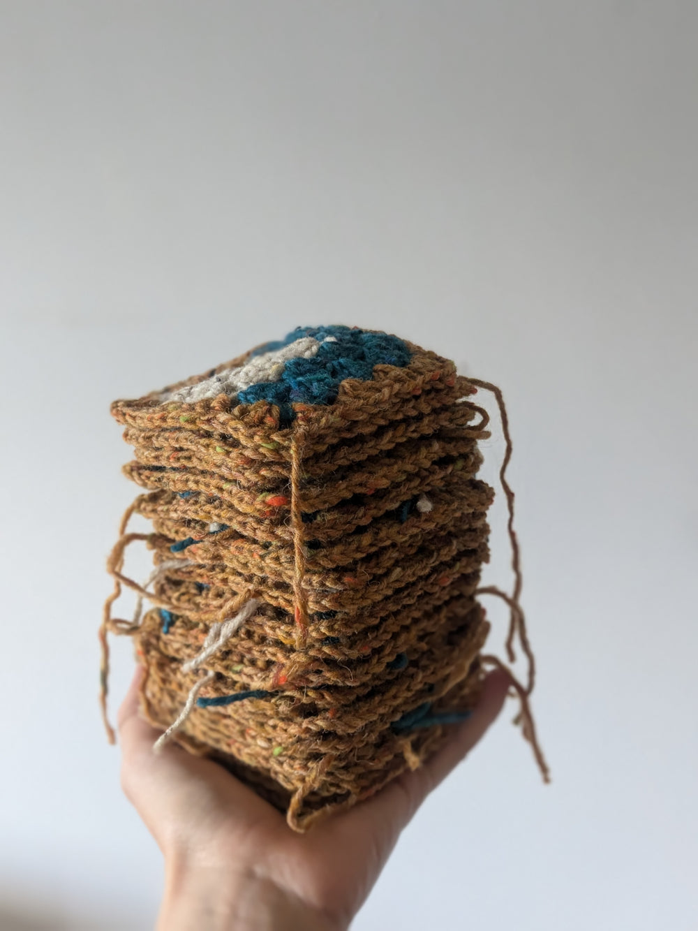 pile de granny square dans une main pour l'atelier de crochet à Montréal. 