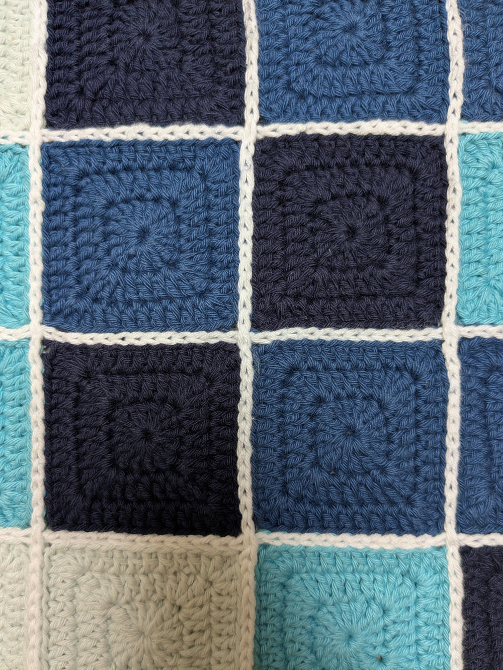 détails oeuvre Les carreaux bleus de l'artiste Agathe Dessaux. Carrés de crochet (granny square) dans les tons bleus assemblés.