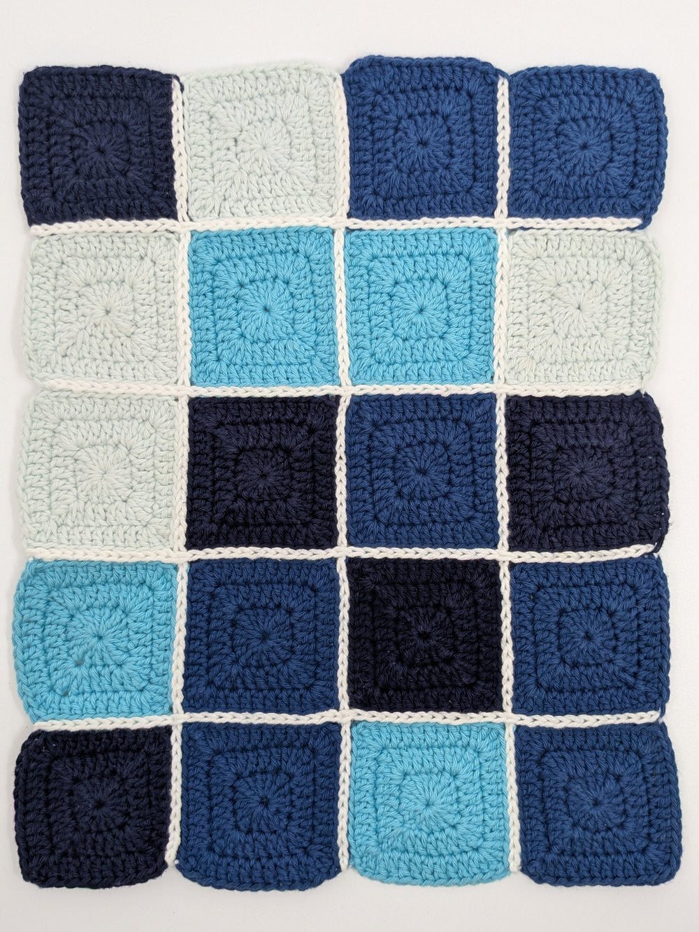 détails oeuvre Les carreaux bleus de l'artiste Agathe Dessaux. Carrés de crochet (granny square) dans les tons bleus assemblés.